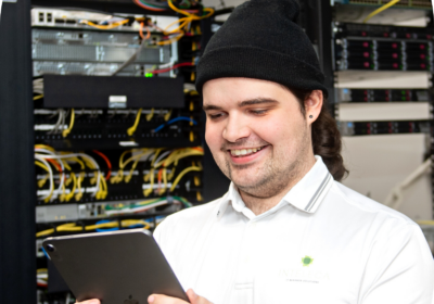 smiling man with beanie looking at a tablet