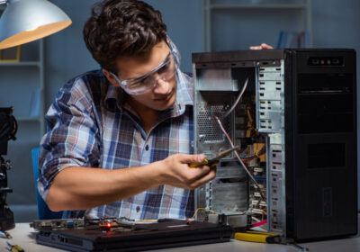 man with protective glasses fixing a desktop computer